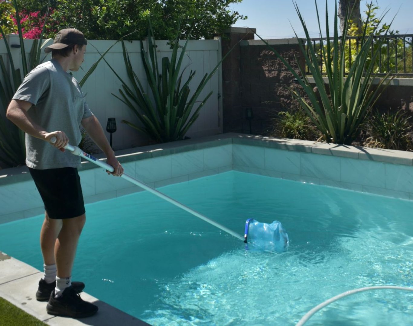 A Pool Service and Repair team member performing pool service in San Bernardino County, CA, showing the value of reliable, expert pool maintenance.